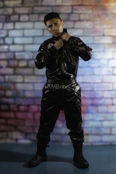 andyscorpiox poses in glossy TwinkX PVC flight suit at Grabbys 2026