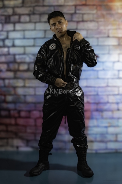 andyscorpiox poses in glossy TwinkX PVC flight suit at Grabbys 2026