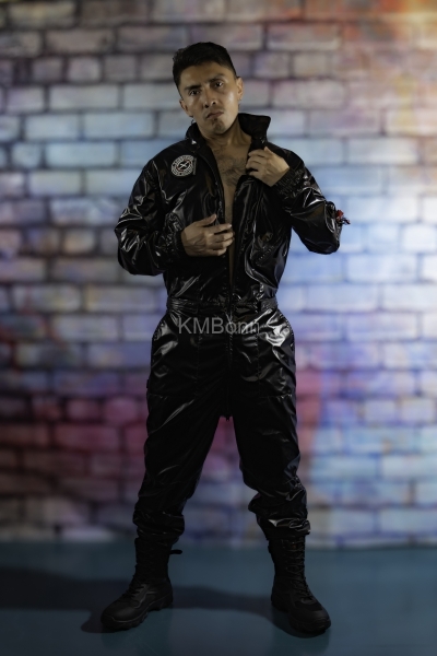 andyscorpiox poses in glossy TwinkX PVC flight suit at Grabbys 2026