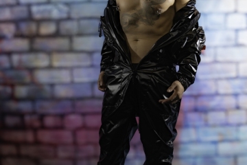 andyscorpiox poses in glossy TwinkX PVC flight suit at Grabbys 2026