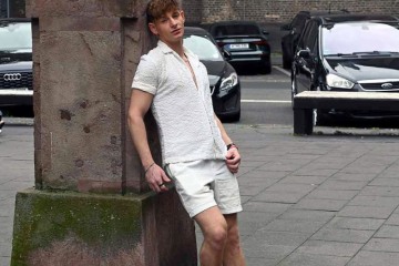Der britische Gay Content Creator John Jai zeigt sich beim provokativen Posing in der Öffentlichkeit. Mit offenem Shirt und direktem, herausforderndem Blick in die Kamera vermittelt er unmissverständlich erotische Abenteuerlust. Seine Körpersprache ist klar: verführerisch, fordernd, voller Spannung – ein Spiel zwischen Exhibitionismus und gezielter Verführung. Die Szene lebt von der Intensität seines Blicks, der den Betrachter festhält und ein klares Signal aussendet: Er braucht es – jetzt.